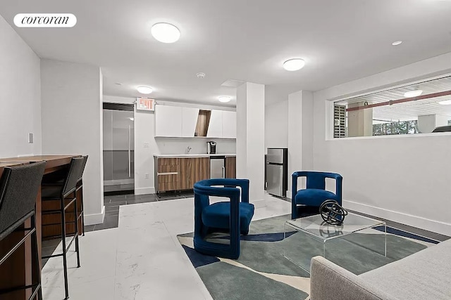dining area with baseboards, dark marble finish flooring, and a community bar