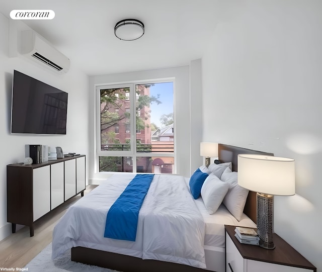 bedroom featuring a wall unit AC and light wood-style floors