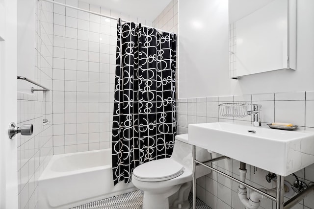 full bath with toilet, tile patterned floors, tile walls, and shower / bathtub combination with curtain