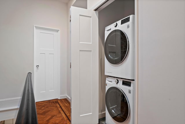 washroom featuring stacked washer / drying machine and laundry area