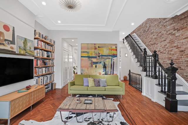 living area with baseboards, brick wall, stairway, parquet floors, and recessed lighting