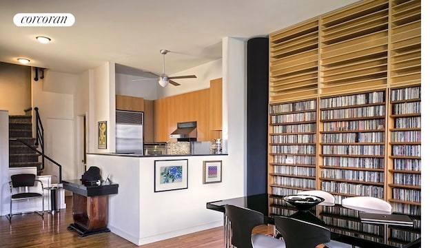 145 Nassau St Unit 8A, New York City, NY 10038 - kitchen with high end fridge, wood finished floors, ceiling fan, under cabinet range hood, and dark countertops