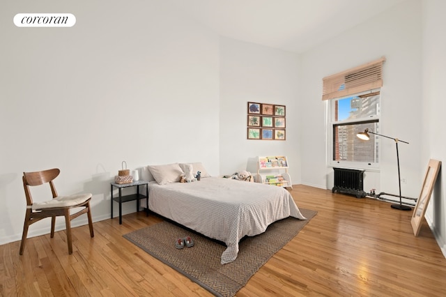 145 Nassau St Unit 8A, New York City, NY 10038 - bedroom featuring light wood-type flooring, baseboards, and radiator