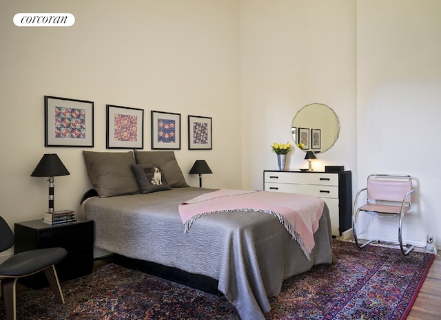 bedroom featuring wood finished floors, visible vents, and baseboards