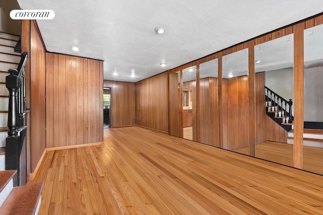 empty room featuring recessed lighting, stairway, light wood finished floors, and baseboards