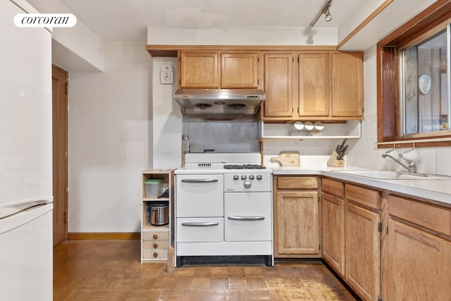 kitchen featuring a sink, baseboards, white appliances, light countertops, and under cabinet range hood