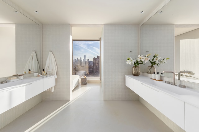 251 W 14th Street Penthouse, New York City, NY 10011 - bathroom with a freestanding tub, concrete flooring, and vanity