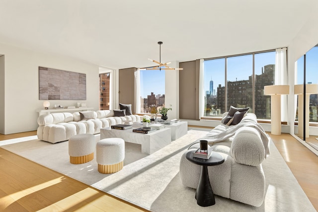 living room featuring a view of city, wood finished floors, and an inviting chandelier