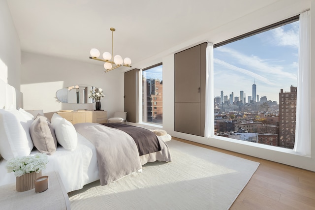 251 W 14th Street Penthouse, New York City, NY 10011 - bedroom featuring wood finished floors, a chandelier, and a skyline view