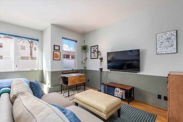 living area with baseboards and wood finished floors