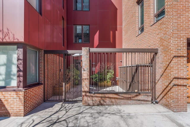 exterior space featuring a gate, brick siding, and fence