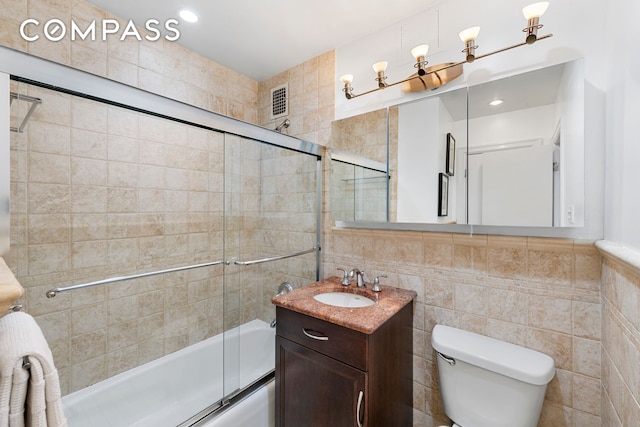 full bath featuring visible vents, combined bath / shower with glass door, tile walls, and toilet