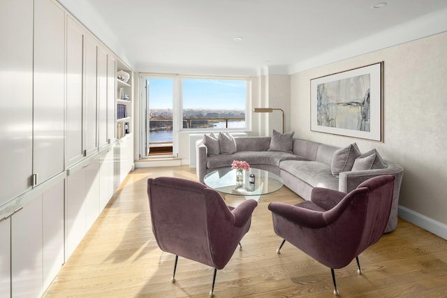 living area with light wood-type flooring and baseboards