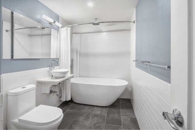 bathroom featuring toilet, a sink, tile walls, tile patterned floors, and a shower with curtain