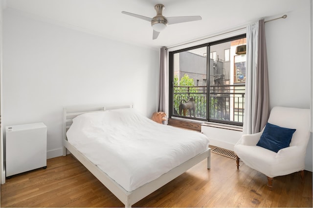 bedroom with baseboards, ceiling fan, visible vents, and wood finished floors