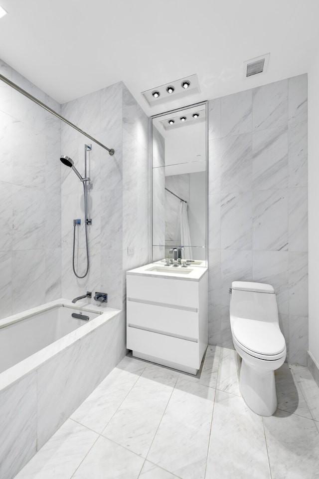 full bath featuring toilet, vanity,  shower combination, visible vents, and tile walls