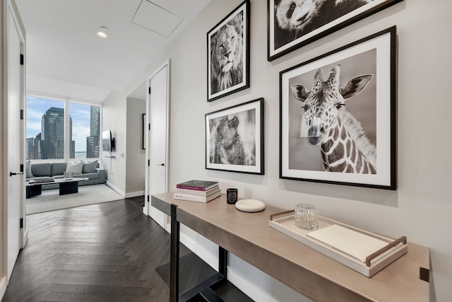 hallway featuring attic access, a view of city, and baseboards