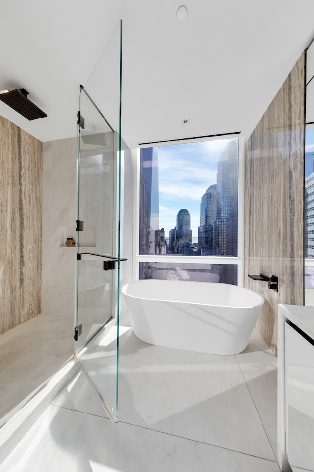 bathroom with tile patterned flooring, a view of city, a freestanding bath, vanity, and a shower stall