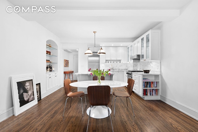 dining area featuring a chandelier, built in features, baseboards, and dark wood-style flooring