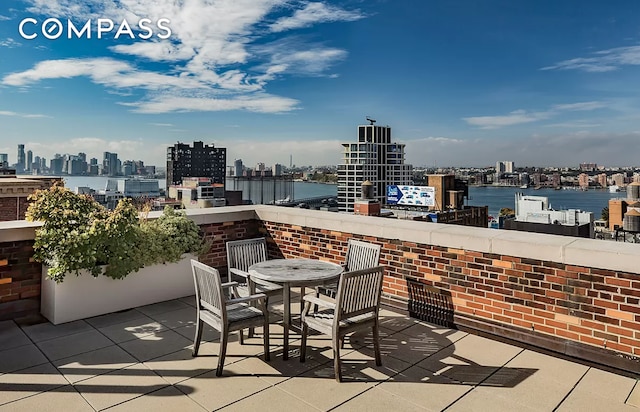 view of patio featuring outdoor dining space, a city view, and a water view