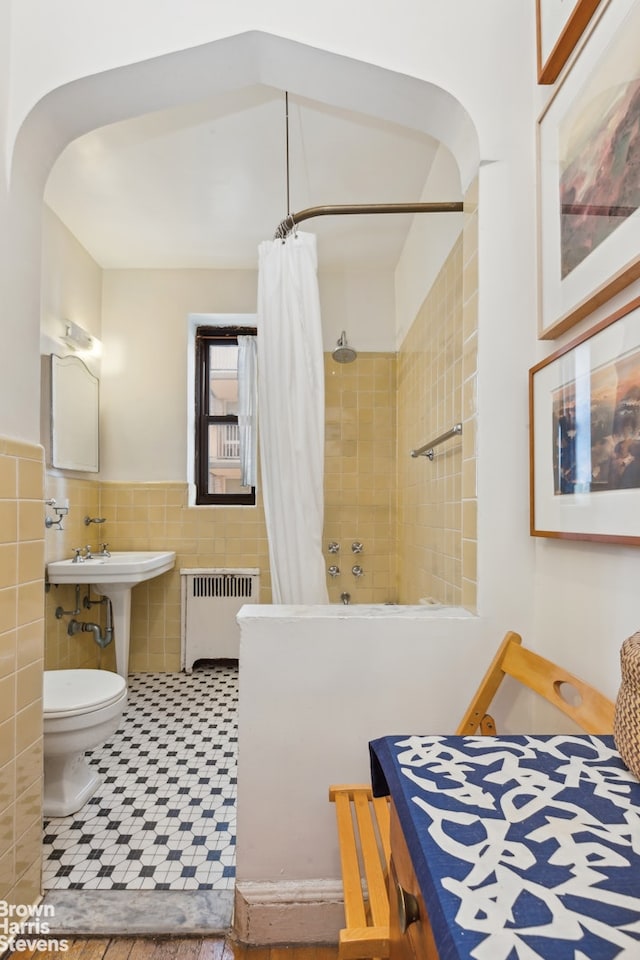 420 E 86th St Unit 4H, New York City, NY 10028 - full bathroom with radiator, tile walls, tiled shower, toilet, and a wainscoted wall