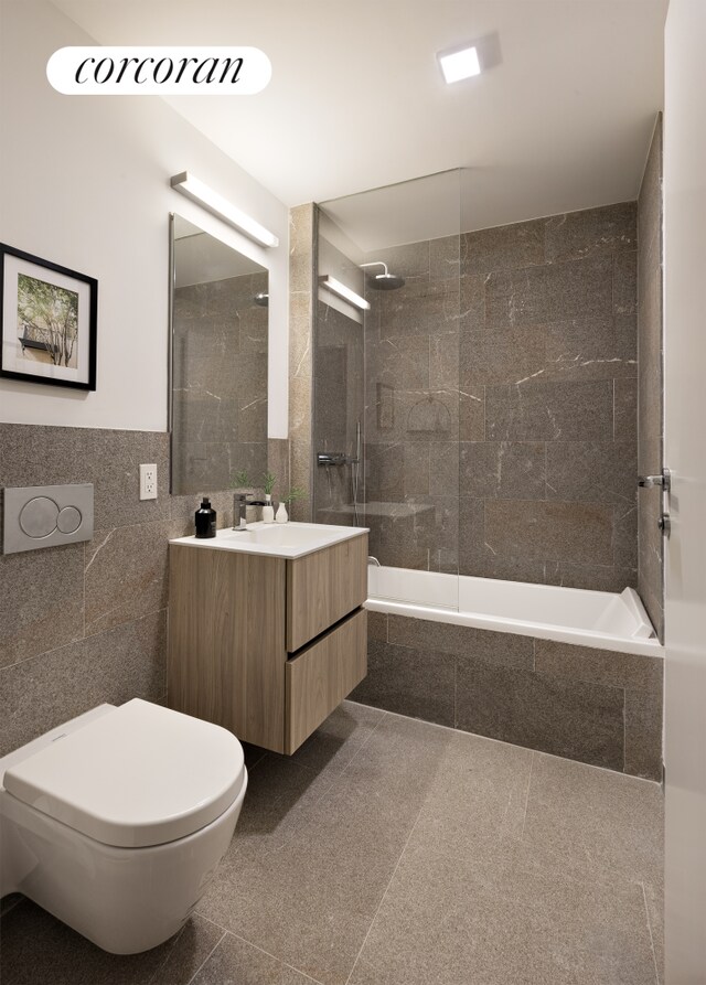 139 E 23rd St Unit 8, New York City, NY 10010 - full bathroom featuring tile walls, tiled shower / bath, vanity, and toilet