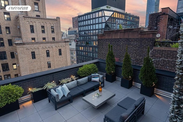 view of patio with a view of city, a balcony, and an outdoor hangout area