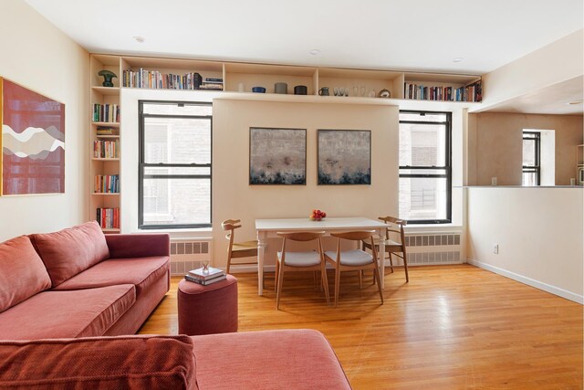 living area featuring radiator, baseboards, and wood finished floors