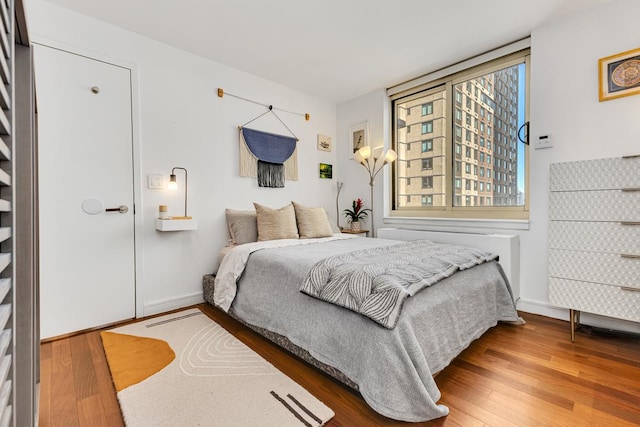 bedroom featuring hardwood / wood-style flooring and baseboards