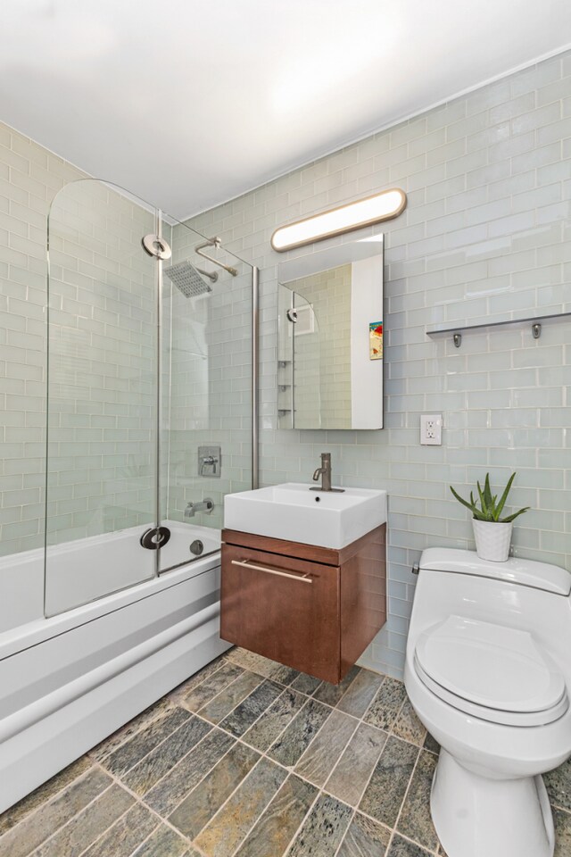 206 E 95th St Unit 7C, New York City, NY 10128 - full bath featuring shower / bath combination with glass door, tile walls, toilet, and vanity