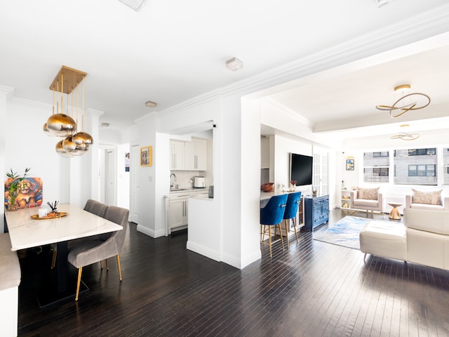 living room featuring dark wood-style flooring, ornamental molding, and baseboards