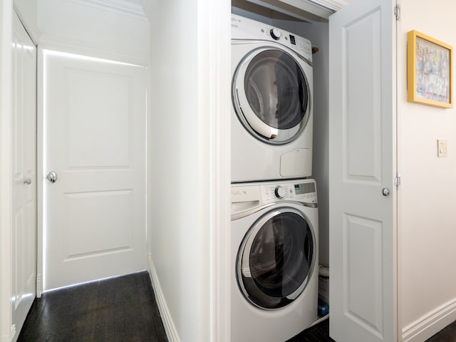 laundry room featuring stacked washer / dryer, baseboards, and laundry area