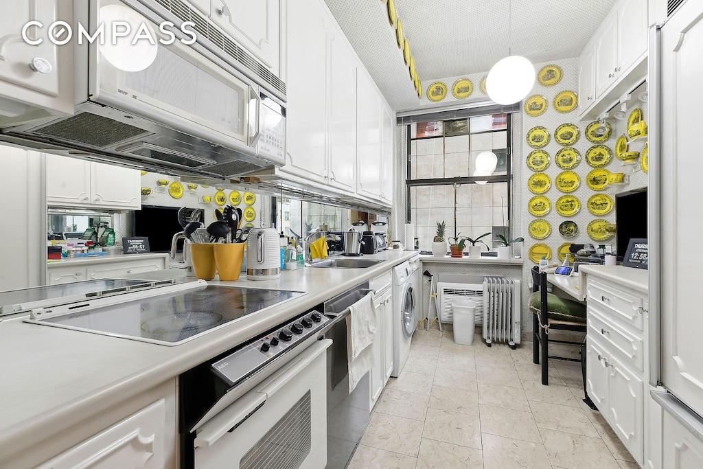 kitchen with white cabinetry, stovetop, washer / clothes dryer, and white microwave