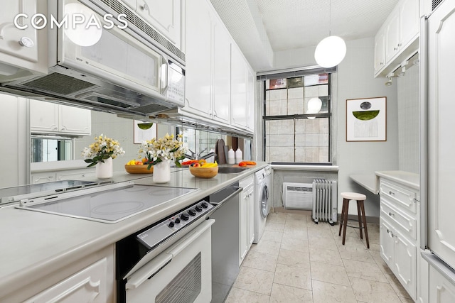 kitchen with light countertops, stovetop, oven, and white microwave