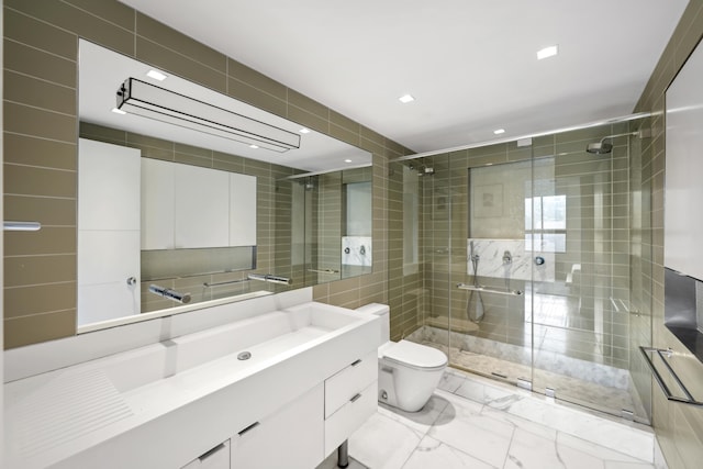 full bathroom featuring marble finish floor, tile walls, toilet, a stall shower, and vanity