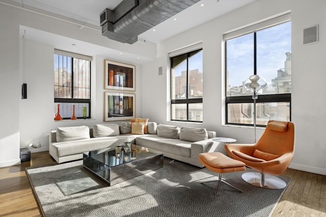 living area featuring hardwood / wood-style flooring, visible vents, baseboards, and recessed lighting