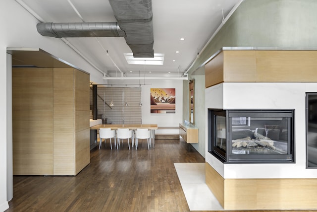 interior space with recessed lighting, dark wood finished floors, and a multi sided fireplace