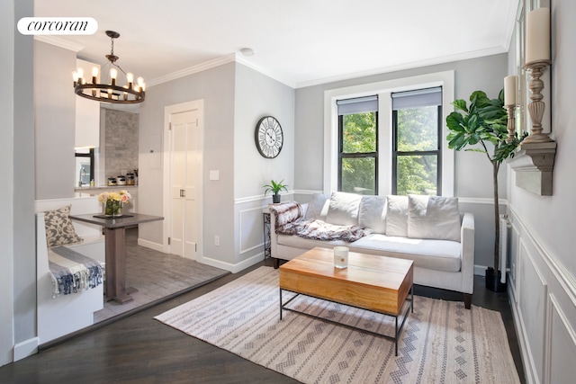 living room featuring visible vents, a wainscoted wall, ornamental molding, wood finished floors, and an inviting chandelier