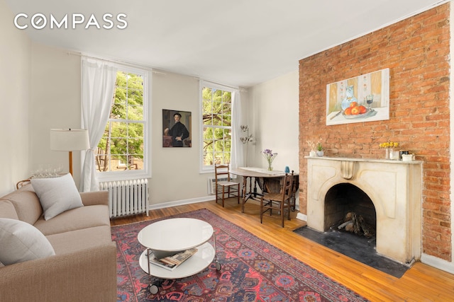 73 Bedford St, New York City, NY 10014 - living room with radiator, wood finished floors, a fireplace with flush hearth, and baseboards