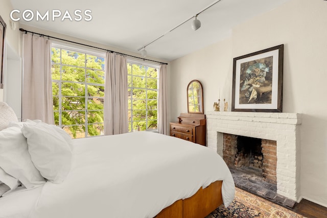 73 Bedford St, New York City, NY 10014 - bedroom with track lighting, a fireplace, and wood finished floors
