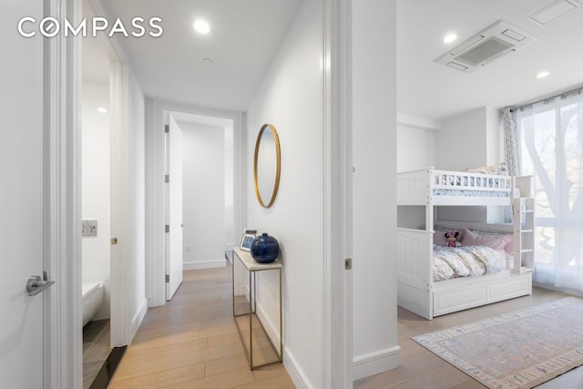 hall with baseboards, light wood-style flooring, and recessed lighting