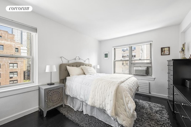 bedroom featuring baseboards, visible vents, and dark wood finished floors