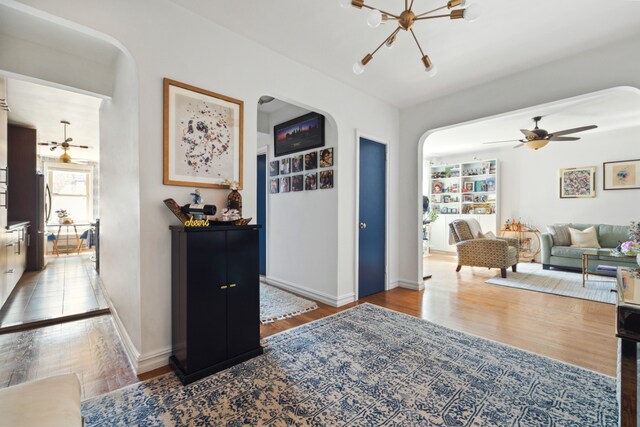 9437 Shore Rd Unit E8, New York City, NY 11209 - living area with arched walkways, a chandelier, wood finished floors, and ceiling fan