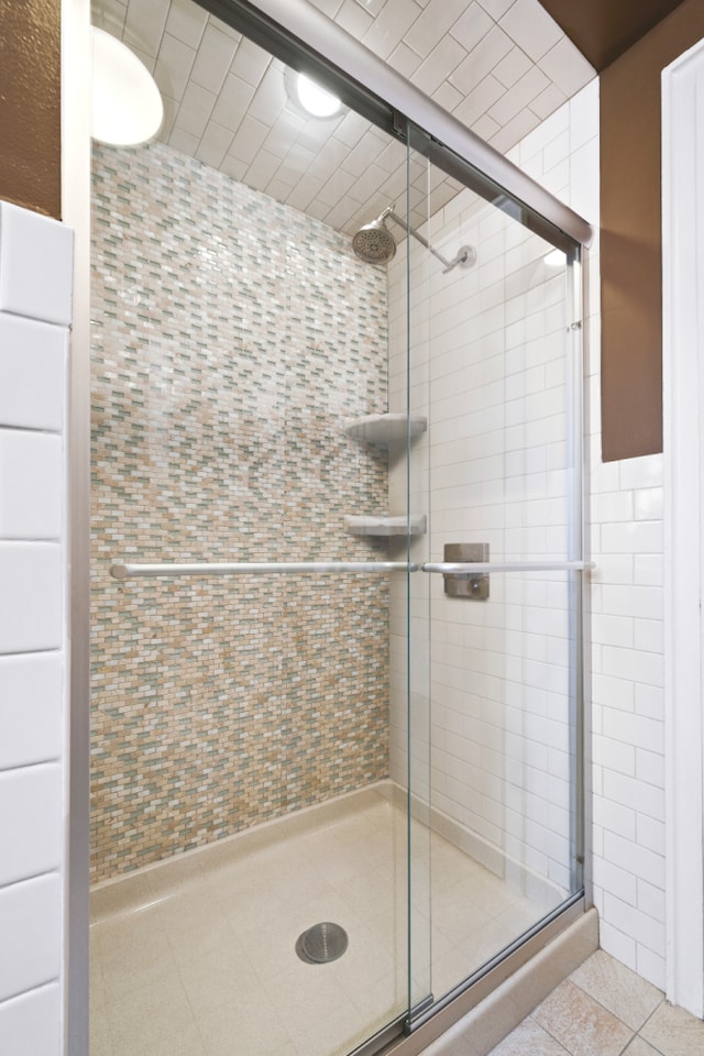 bathroom with tile patterned flooring and a stall shower