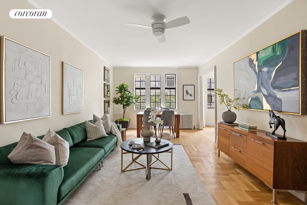 living room with crown molding, a ceiling fan, radiator heating unit, and visible vents