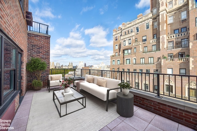 view of patio / terrace featuring a balcony, an outdoor hangout area, and a city view