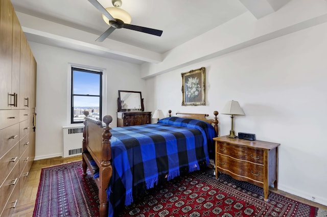 bedroom featuring ceiling fan, beamed ceiling, radiator heating unit, and baseboards