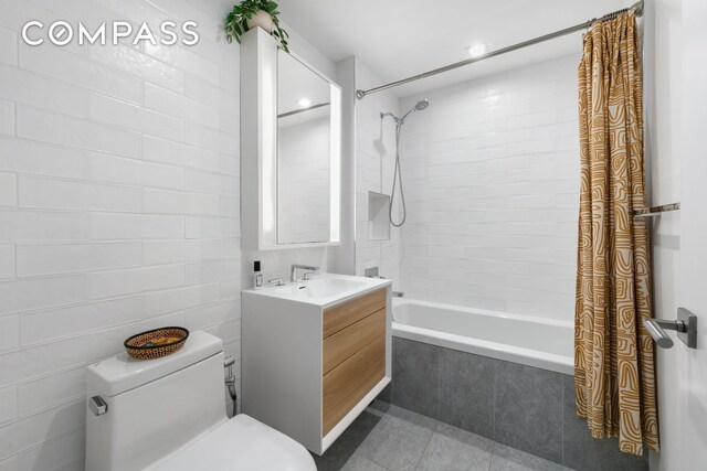 full bath featuring tile patterned floors, toilet, vanity, and tiled shower / bath combo