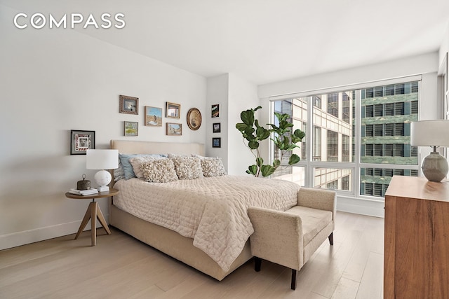 bedroom with light wood-type flooring and baseboards