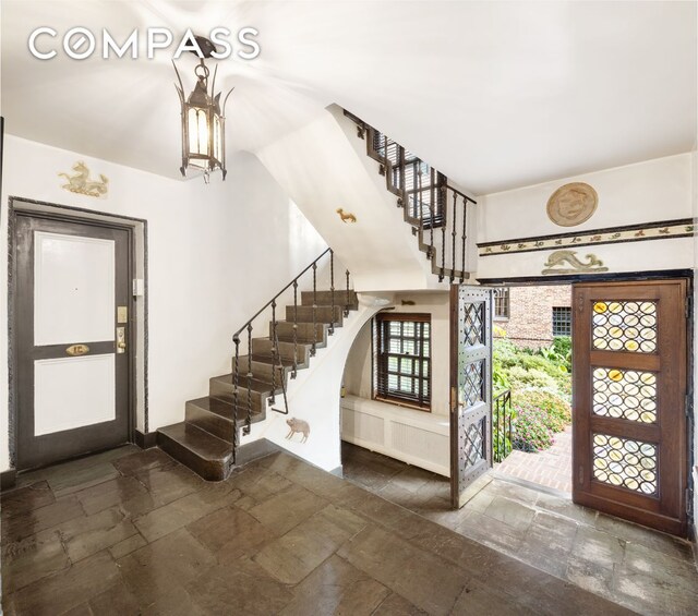 foyer featuring stairway and stone tile flooring